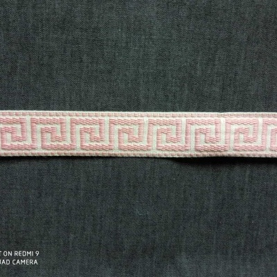 Fita decorativa rosa e branca com padrão geométrico sobre tecido preto