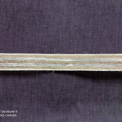 Fita elástica bege sobre tecido roxo escuro