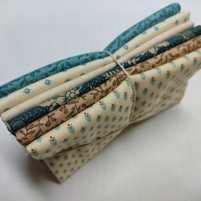 Tecido dobrado com padrões florais e de pontos em azul, castanho e bege