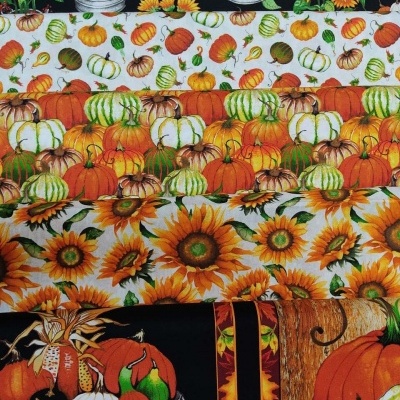 Tecidos com padrões de abóboras e girassóis em vários tons, fundos preto e branco.