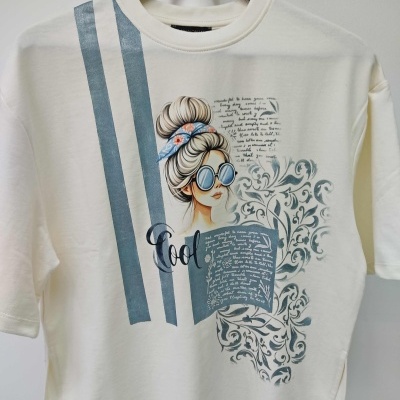 Camiseta creme com estampa de mulher desenhada, riscas azuis e desenhos florais cinzentos