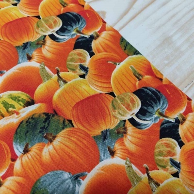 Tecido estampado com padrão de abóboras coloridas sobre fundo preto