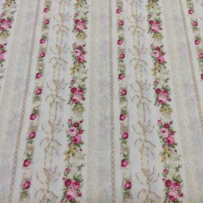 Tecido branco com riscas verticais de flores vermelhas, amarelas, folhas verdes e laços castanhos claros.