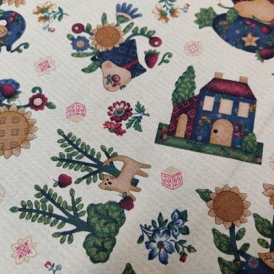 Tecido branco com padrões coloridos de casas, flores, animais e árvores