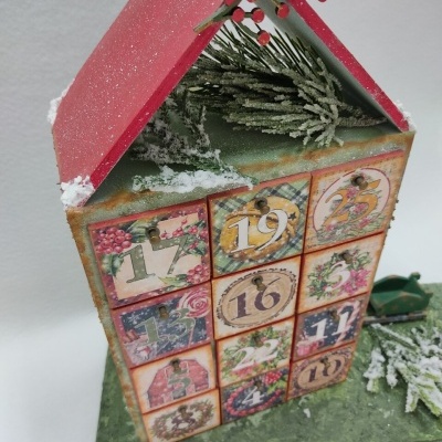 Calendário do advento decorativo em forma de casa com pequenos compartimentos numerados