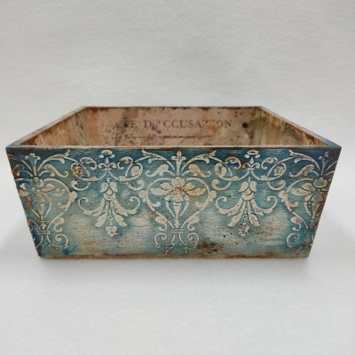 Caixa decorativa azul envelhecida com padrão floral branco em relevo
