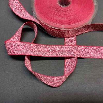 Fita vermelha e branca enrolada em carretel sobre fundo escuro