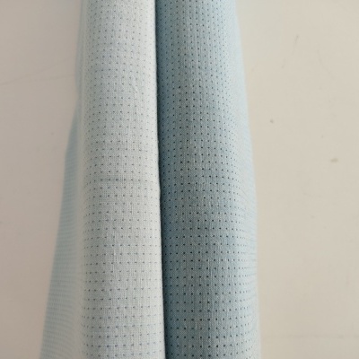 Dois tecidos azuis claros com textura perfurada pendurados