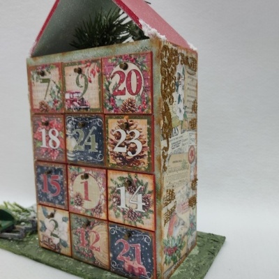 Calendário do advento em forma de casinha decorada com padrões florais e gavetas numeradas