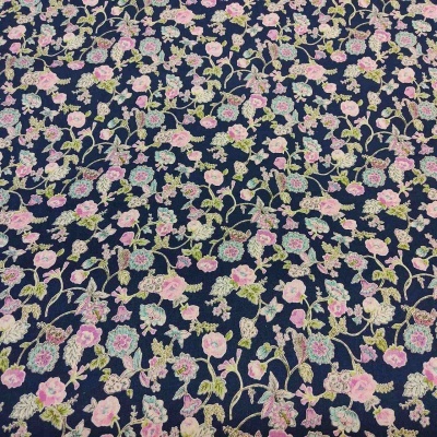 Tecido azul escuro com padrão floral bordado em tons de rosa, verde e azul claro