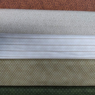 Cinco rolos de tecido com padrões pequenos em castanho, branco, branco riscado, bege e verde escuro