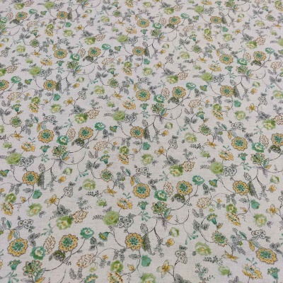 Tecido branco com flores verdes, amarelas e cinzentas, folhas e ramos desenhados