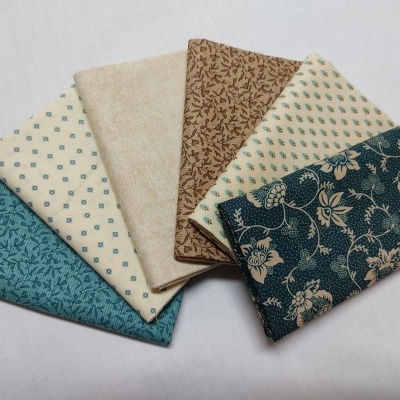 Seis tecidos dobrados com padrões florais e geométricos em tons de azul, castanho, bege e creme