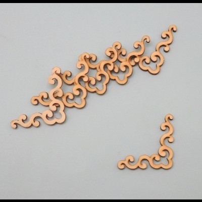 Peças decorativas em madeira clara com padrões curvos e flores estilizadas