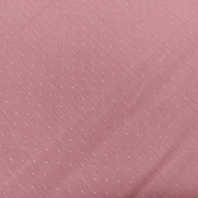 Tecido rosa com pequenos pontos brancos
