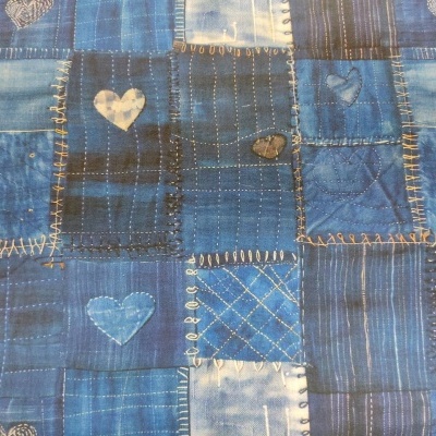 tecido azul de patchwork com corações bordados e padrões variados
