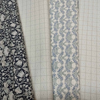 Quatro tecidos com padrões florais e geométricos em preto, branco e azul