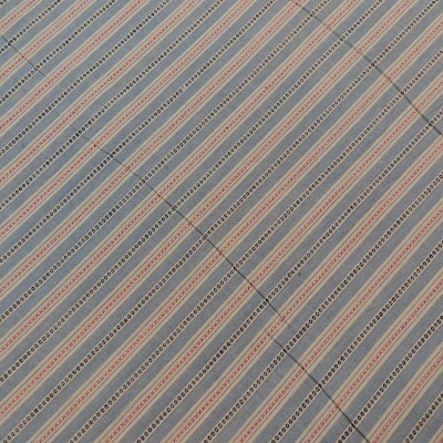 Tecido com padrão de listras diagonais em azul claro, laranja e cinza