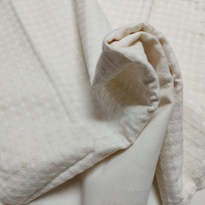 Tecido branco com padrão texturizado e dobrado