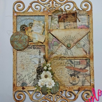 Objeto decorativo em metal com papéis vintage, envelopes, flores artificiais e padrão trabalhado.
