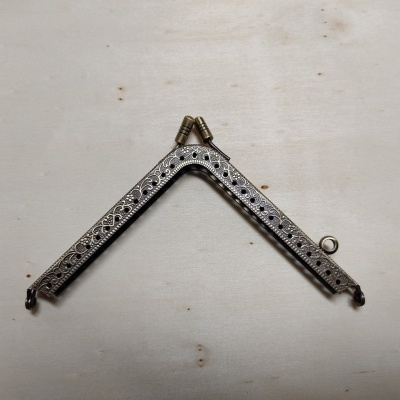 fecho metálico prateado para bolsa com design decorativo em relevo