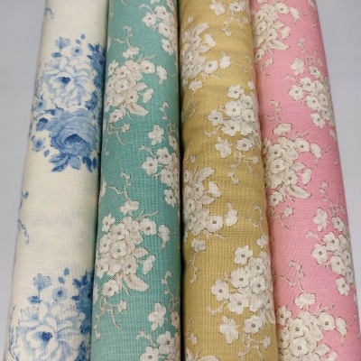 Quatro rolos de tecido floral colorido com padrão de flores pequenas