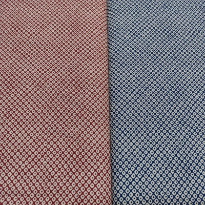 Tecido com padrão geométrico vermelho e azul com losangos brancos