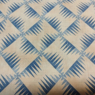 Tecido bege com padrão geométrico azul em losangos
