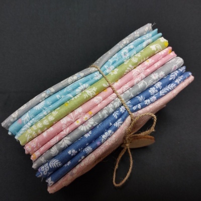 Conjunto de tecidos coloridos com padrões florais amarrados com cordão