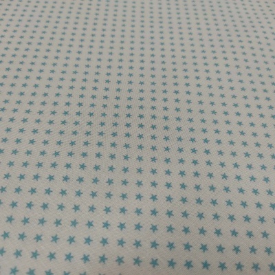 Tecido branco com padrão de pequenas estrelas azuis