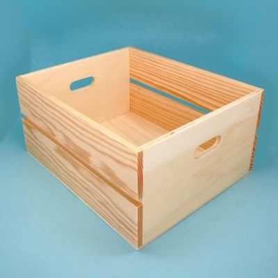 Caixa de madeira natural com puxadores recortados, sobre superfície azul clara.