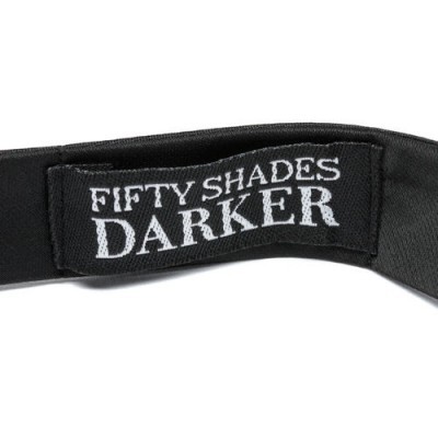 Faixa preta com etiqueta bordada 'FIFTY SHADES DARKER'.