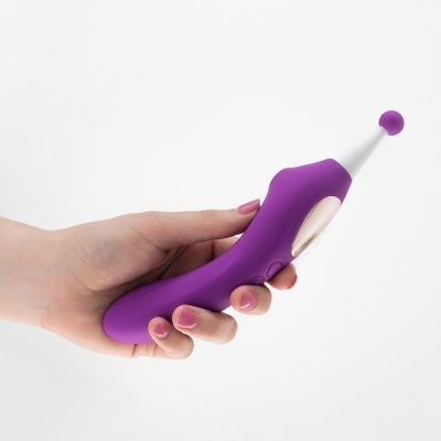 Aparelho portátil curvo em silicone roxo e branco segurado por uma mão