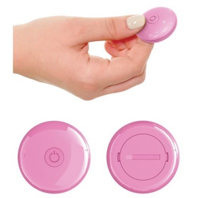Dispositivo redondo rosa com botão, segurado por mão.