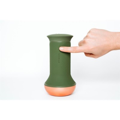 Dispositivo portátil verde com base cor de cobre e mão apontando para ele