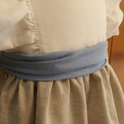 Cinto azul claro em tecido suave no vestido bege com saia franzida