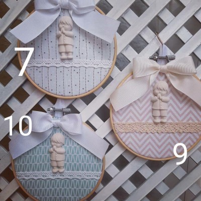 Três bastidores de madeira com tecidos estampados e figuras de menino decorativas