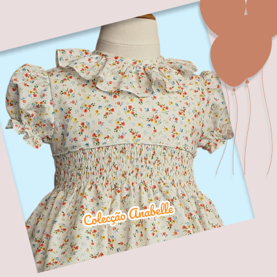 Vestido infantil branco com padrão floral e folho no colarinho