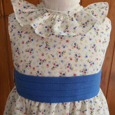 Vestido infantil branco com flores pequenas e cinto azul largo