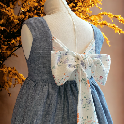 Vestido azul claro com laço floral branco nas costas em manequim