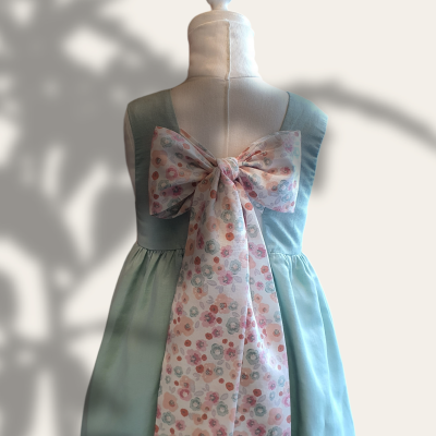 Vestido azul claro com laço floral rosa nas costas