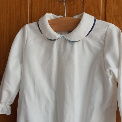 Camisola branca de criança com gola Peter Pan e detalhes em azul e floral