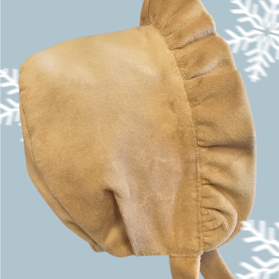 Gorro bege com babados e textura suave em fundo azul com flocos de neve