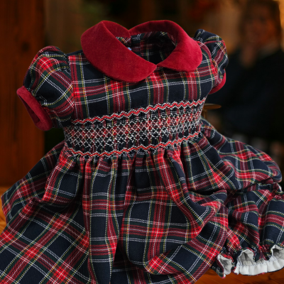 Vestido infantil xadrez com gola e punhos vermelhos em veludo e bordado smock