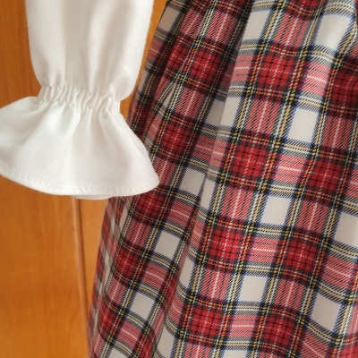 Manga branca com punho franzido e tecido principal em padrão de xadrez vermelho e branco