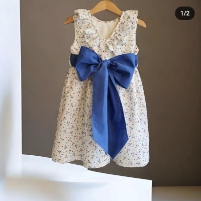 Vestido infantil branco com padrão floral e laço azul na cintura