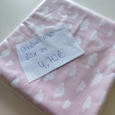 Retalho de tecido rosa com nuvens brancas e nota manuscrita com preço e dimensão.