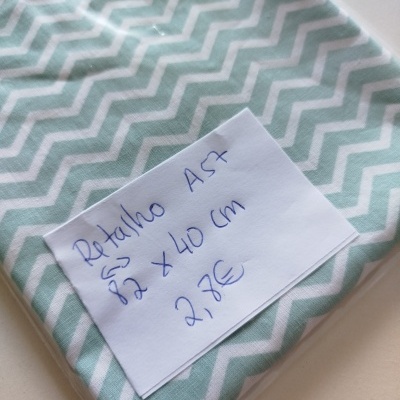 Tecido com padrão zig-zag branco e verde-água com etiqueta manuscrita colocada