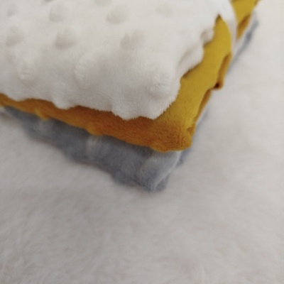 Três tecidos macios empilhados em branco, amarelo e cinza sobre superfície branca