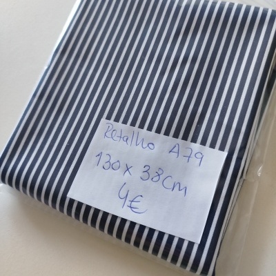 Pano tecido de riscas brancas e azuis embalado em plástico com etiqueta manuscrita